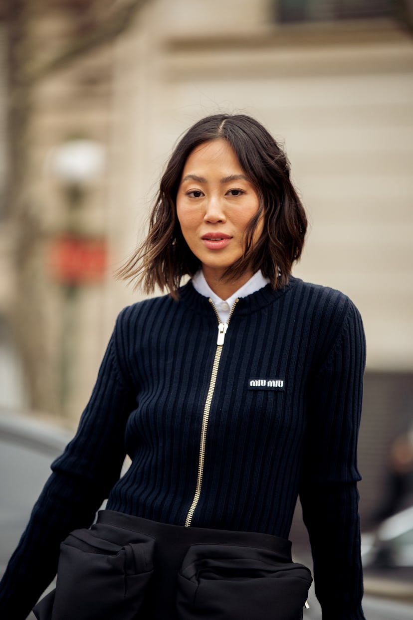 Aimee Song wears a navy blue knitted mini dress with a Miu Miu black mini skirt on top, Miu Miu blac...