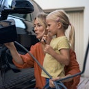 Mother and daughter refueling electric car