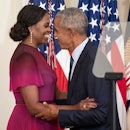 Former First Lady Michelle Obama and former U.S. President Barack Obama embrace at a ceremony to unv...