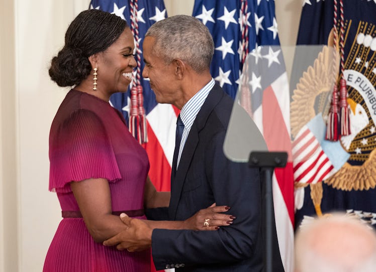 Former First Lady Michelle Obama and former U.S. President Barack Obama embrace at a ceremony to unv...