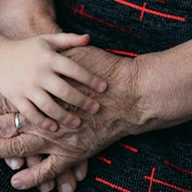 The hands of a child and an elderly person. The flabby skin of a pensioner. Grandmother and granddau...