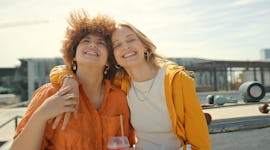 two friends embrace at a skate park as they consider which zodiac signs are the most socially awkwar...