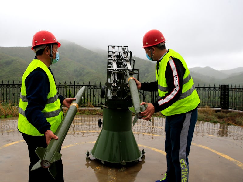 SHIJIAZHUANG, CHINA - MAY 15: Workers of local meteorology bureau fire a cloud-seeding rocket in an ...