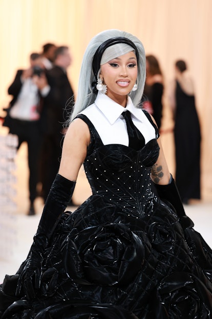 Cardi B attends the 2023 met gala wearing a silver bouffant hair and a dramatic cat eye