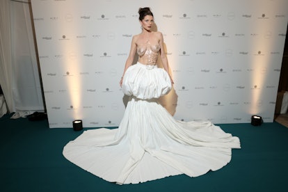 Julia Fox wears a clear breast plate and a high-waist white skirt at The Art of Elysium "Paradis" 25...