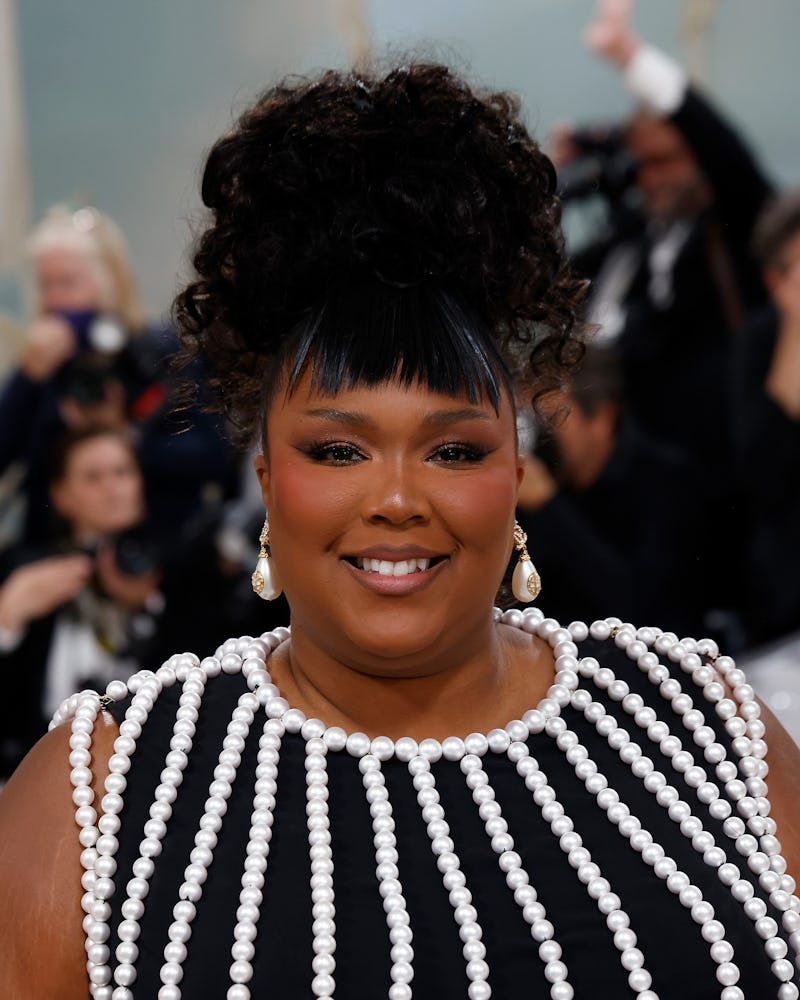 A portrait photo of Lizzo at the 2023 Met Gala wearing a pearl-encrusted dress.