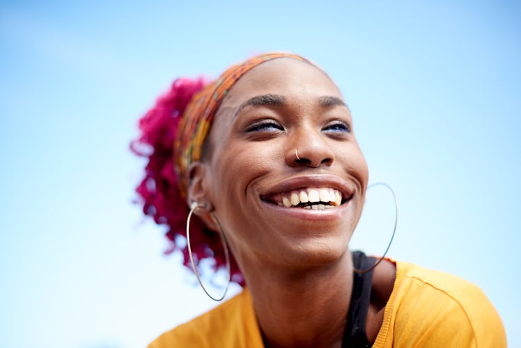 young woman with pink hair smiles in a portrait as she considers how the June 2023 full strawberry m...