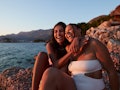 two women smile and embrace as they enjoy golden hour at the beach and consider the spiritual meanin...