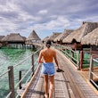 She walks over tropical waters, in luxury resort