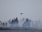 CAPE ELIZABETH, ME - APRIL 14: A helicopter prepares to douse a controlled burn on Richmond Island t...