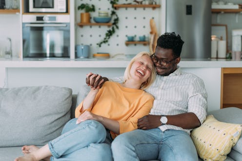 Shot of a cheerful young couple embracing on the sofa at home.