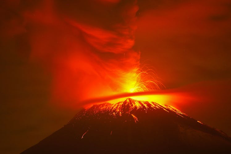 TOPSHOT - Incandescent materials, ash and smoke are spewed from the Popocatepetl volcano as seen fro...
