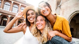 three friends pose for a selfie during vacation as they consider how the June 2023 full strawberry m...
