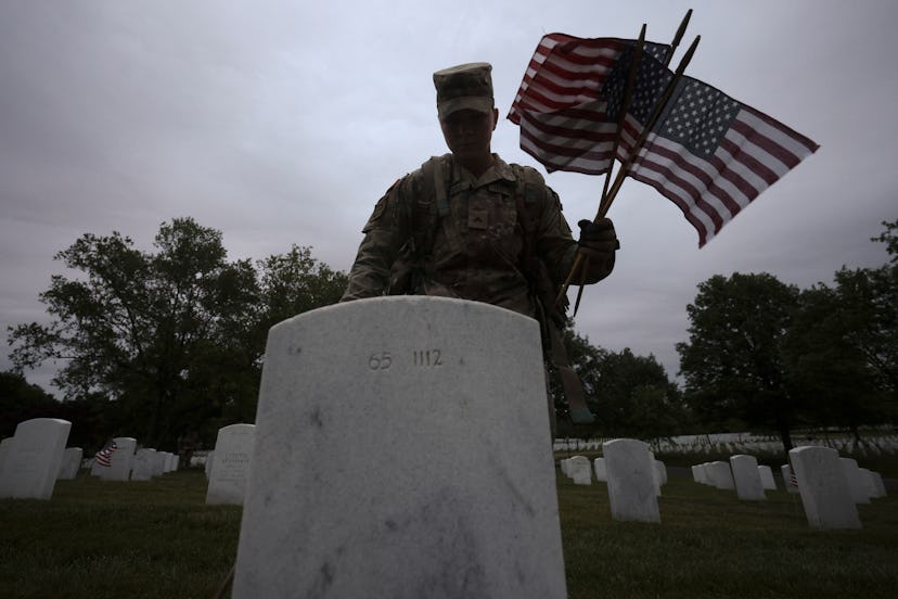 ARLINGTON, VIRGINIA - MAY 25: Members of the 3rd U.S. Infantry Regiment place flags at the headstone...