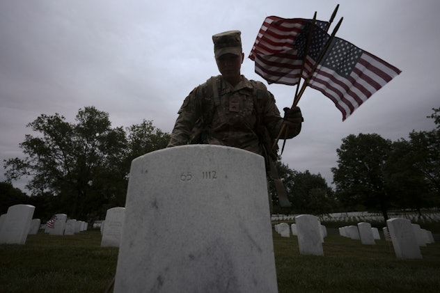 ARLINGTON, VIRGINIA - MAY 25: Members of the 3rd U.S. Infantry Regiment place flags at the headstone...