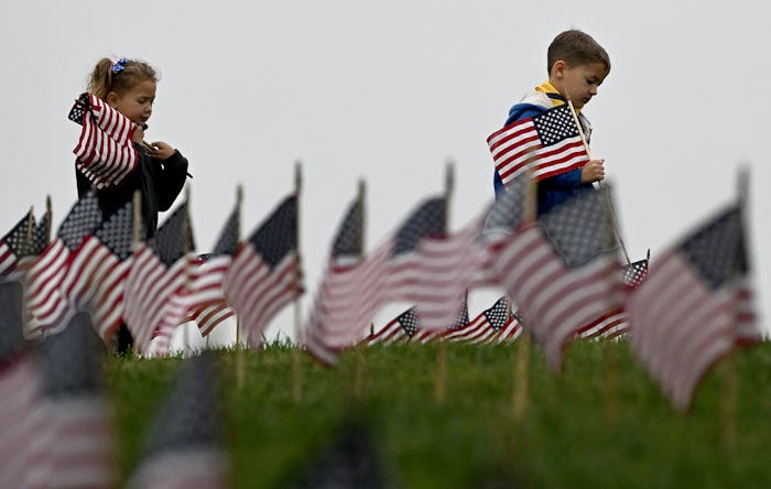 Riverside, CA - May 27: Aiden Cartwright, right, 6 from Ontario, places American flags on graves at ...