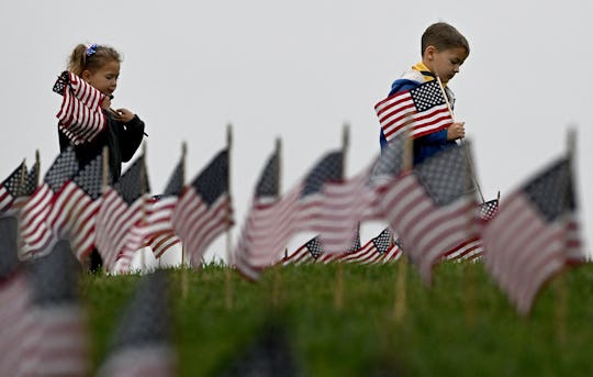 Riverside, CA - May 27: Aiden Cartwright, right, 6 from Ontario, places American flags on graves at ...