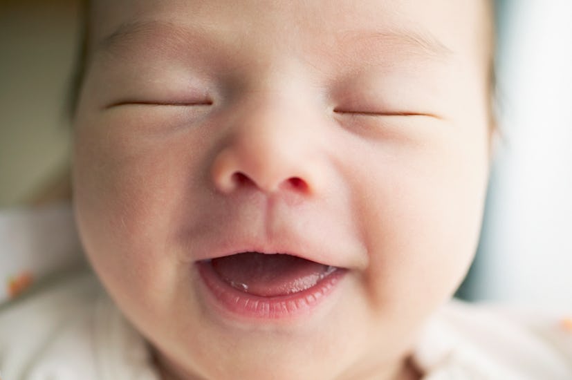 newborn infant smiling is a great photo to include in a birth announcement card