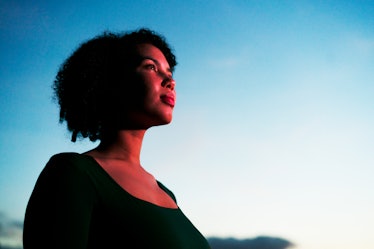 Young woman looking up at the night sky, wondering about the eight moon phases.