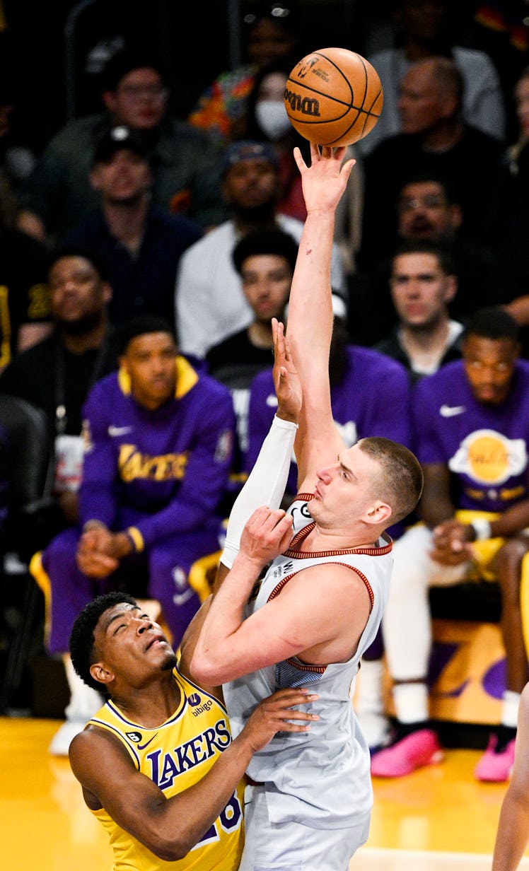Denver Nuggets center Nikola Jokic, right, shoots over Los Angeles Lakers forward Rui Hachimura duri...