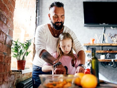 Dad and daughter spend time together in a grunge-style apartment and cook a salad together. A man of...