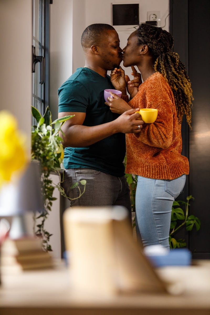 Profile view of romantic young couple sharing bonding moments of affection. They are standing face t...