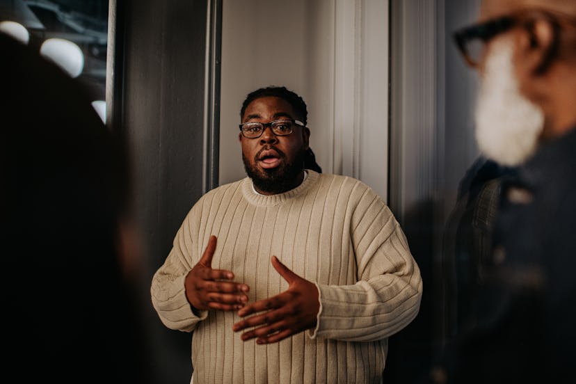A man has a serious expression as he interrupts his onlookers.