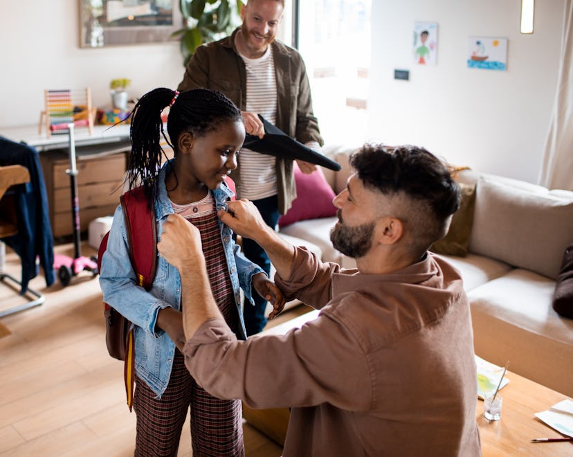 Close up of two fathers greeting daughter from school in article about after school questions