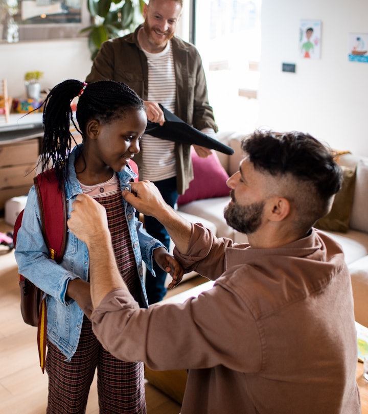 Close up of two fathers greeting daughter from school in article about after school questions