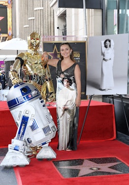 Actress Billie Lourd poses with Star Wars character R2D2 and C3PO