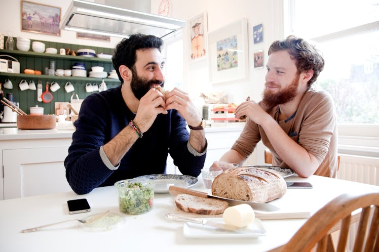 A married couple sitting at a table in their kitchen and eating