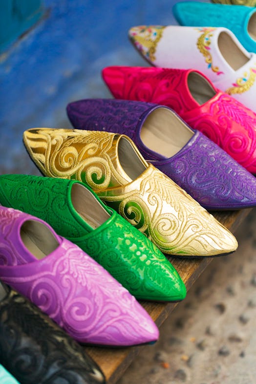 CHEFCHAOUEN, MOROCCO - 27th APRIL 2016 - Colourful hand made slippers and shoes hang for sale in the…