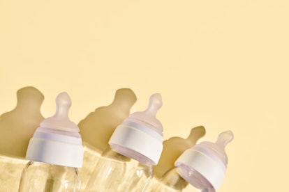 baby bottles on a yellow background. in an article about freeze dried breast milk
