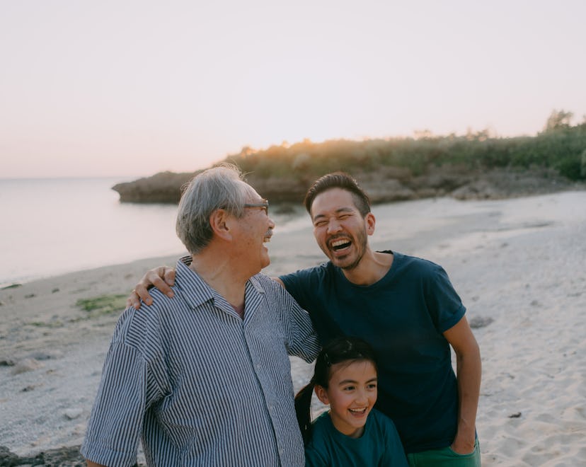 Senior father, adult son and granddaughter having a good time on beach in a story about Father's Day...