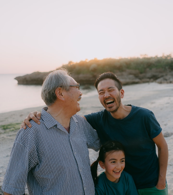 Senior father, adult son and granddaughter having a good time on beach in a story about Father's Day...