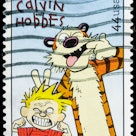 A USA postage stamp of Calvin and Hobbes making funny faces. Calvin is blonde and has a red shirt an...