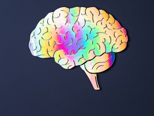 Bright Iridescent Human Brain of Holographic Paper Craft on Purple Background.