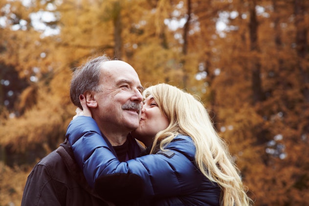 Adult daughter kisses her father on the cheek, in a story about Father's Day Facebook post ideas.