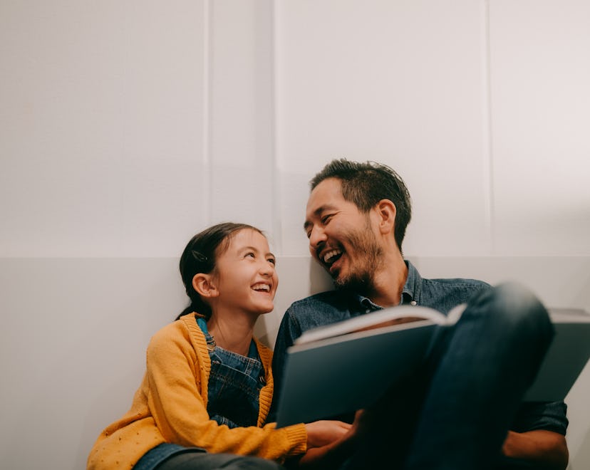 Father and young daughter laughing together over father's day riddles and dad jokes