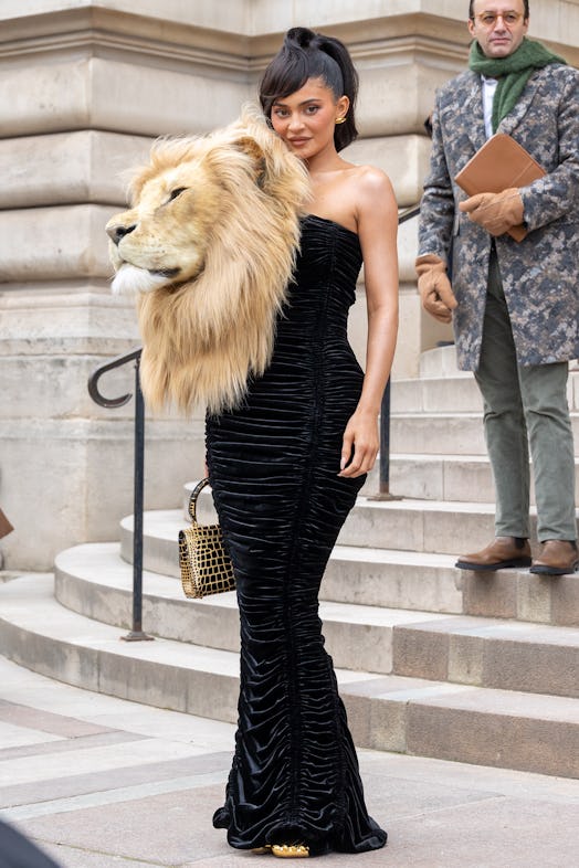 Kylie Jenner wears a black strapless dress with a life-size lion head to attend the Schiaparelli Hau...