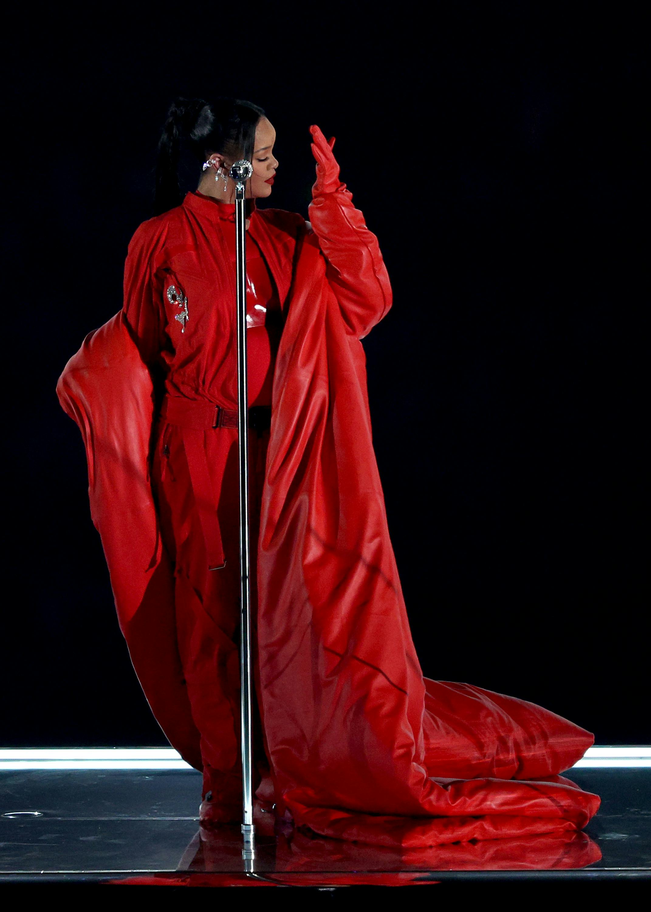 Rihanna wears a red cape and breastplate during the Apple Music Super Bowl LVII Halftime Show.