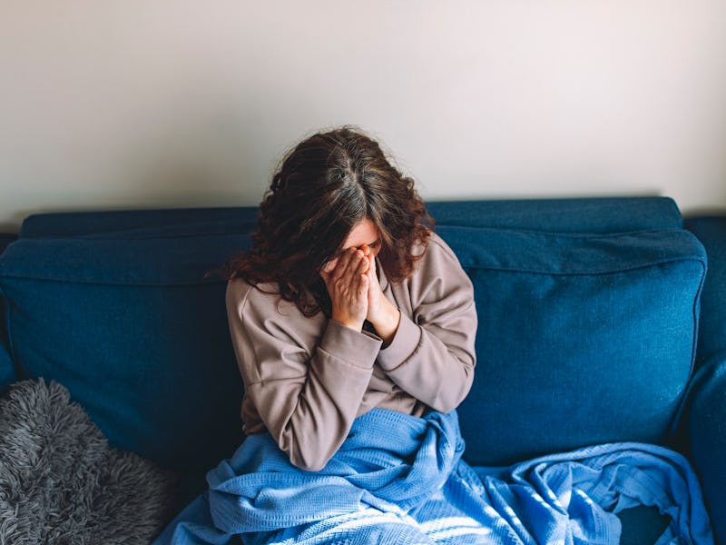 Depressed adult woman on sofa at home