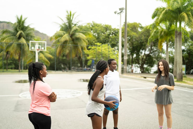 A multiethnic group of friends having a friendly match of pickup basketball in a local public basket...