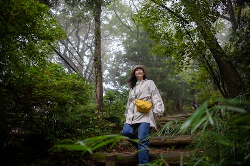 Woman walking down on wooden log steps in mountain