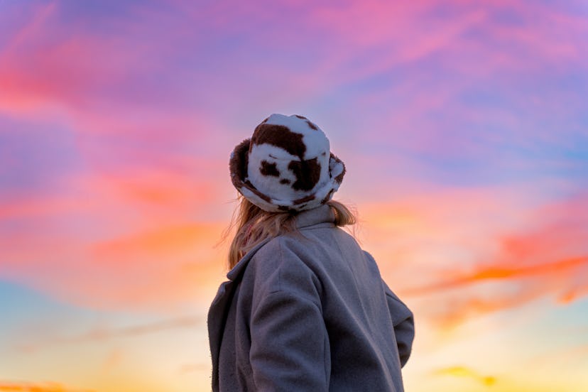 Alone and warm woman enjoying the colors that spring brings and that lights up even more during a be...