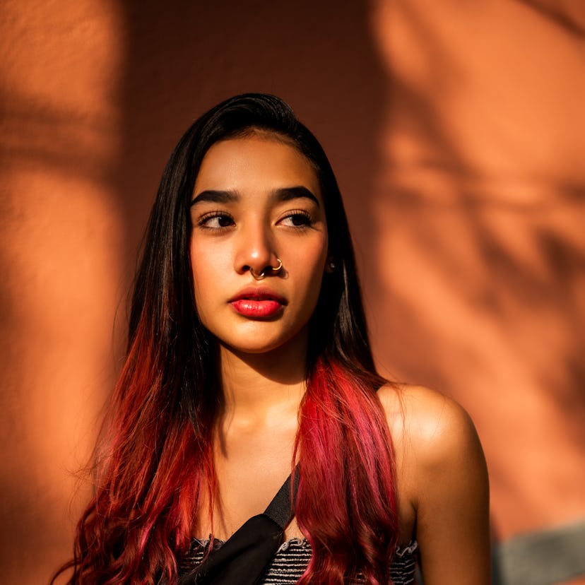 A young woman with a nose ring thinking of the spiritual meaning of the July 2023 Super Buck Moon.