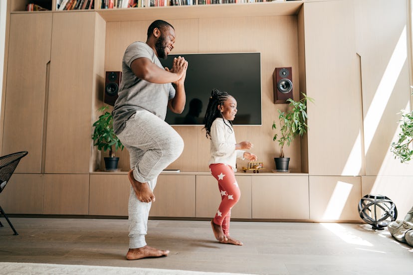 Dad and daughter practicing yoga together on father's day