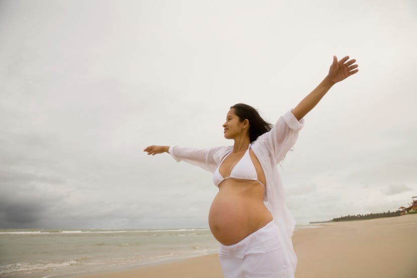 woman in swimsuit on the beach in article about pregnancy safe self tanners