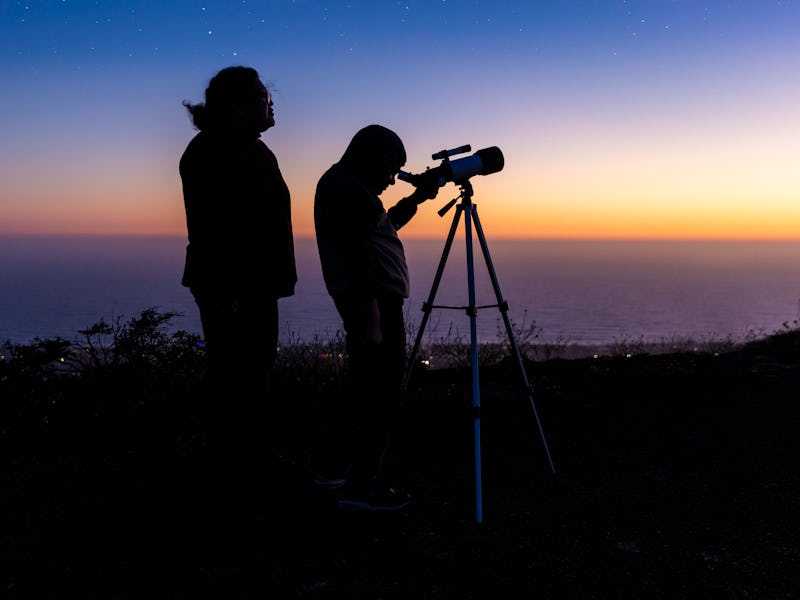 High quality stock photo of a boy stargazing with his mother after the sun sets.