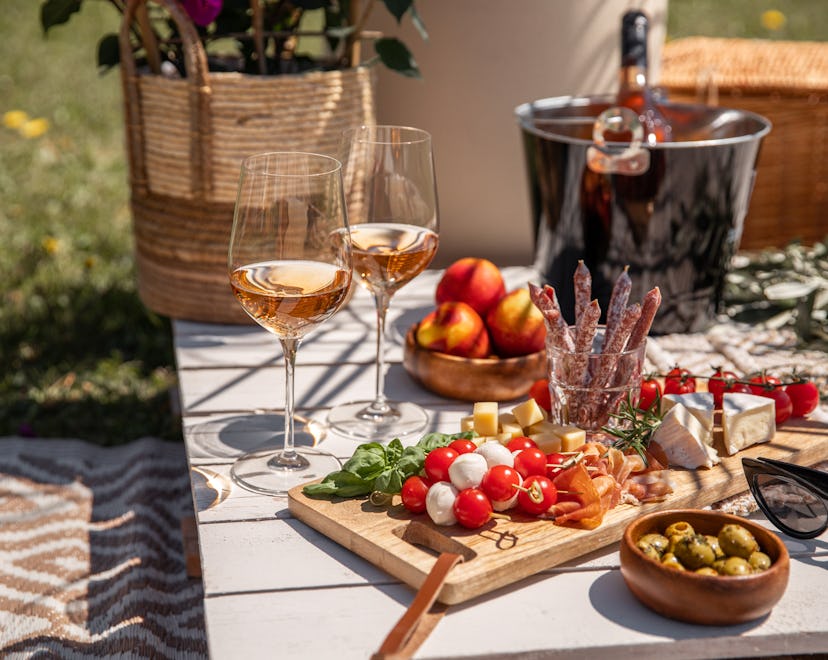 rose wine glasses with summer solstice recipes on sunny garden party table